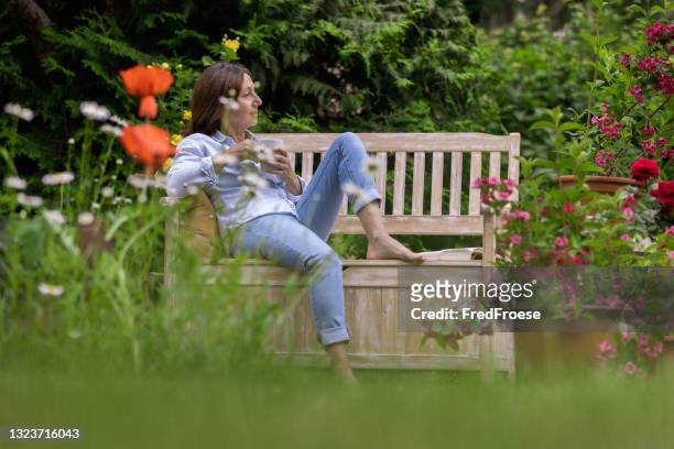 gardening - woman enjoy relaxing in the garden - garden bench stock pictures, royalty-free photos & images