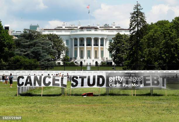 As college students around the country graduate with a massive amount of debt, advocates display a hand-painted sign on the Ellipse in front of The...