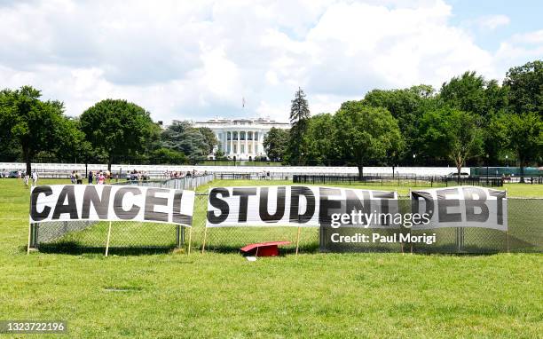 As college students around the country graduate with a massive amount of debt, advocates display a hand-painted sign on the Ellipse in front of The...