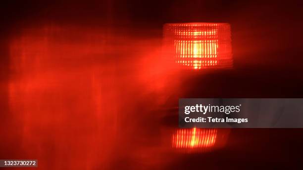close-up of flashing red emergency light at night - wachsamkeit stock-fotos und bilder