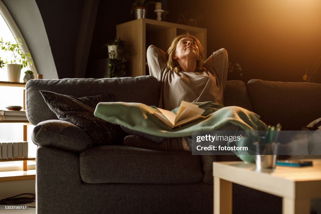 Woman relaxing on the sofa and contemplating after reading a book