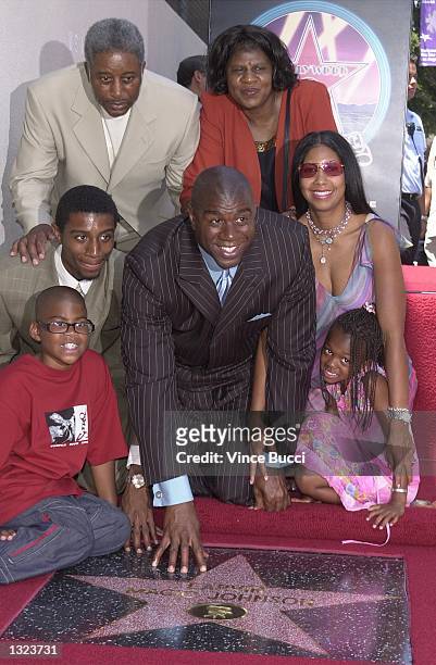 Basketball legend Earvin "Magic" Johnson, center, poses with his family during ceremony honoring him with the 2,180th star on the Hollywood Walk of...