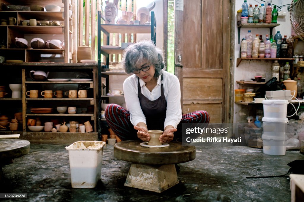 Femmes moyennes travaillant sur la fabrication d’objets en argile dans l’atelier de poterie