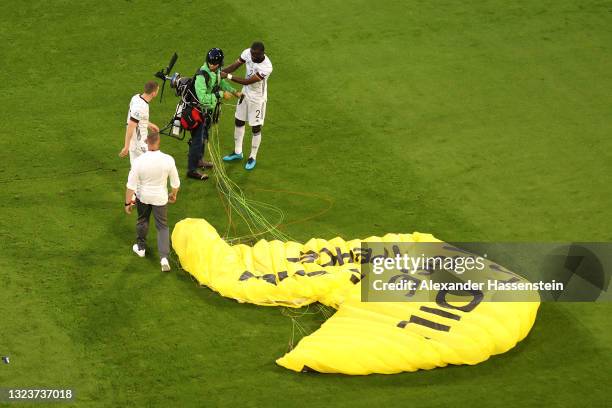 Greenpeace protester and pitch invader is helped up by Antonio Ruediger of Germany on the pitch prior to the UEFA Euro 2020 Championship Group F...