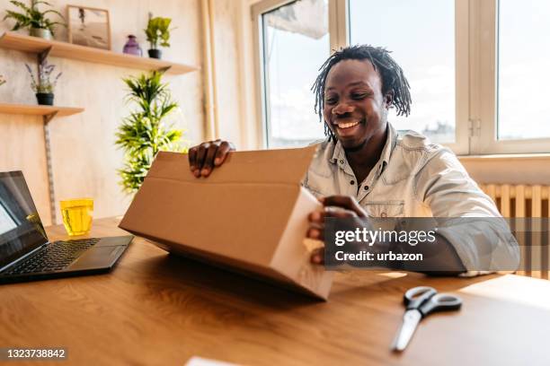 man customer opening cardboard box parcel - african gift stock pictures, royalty-free photos & images