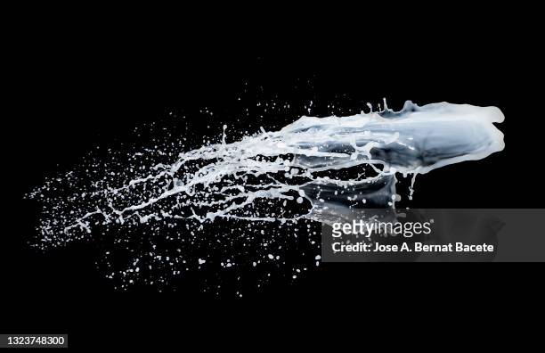 splashes and drops of milk on a black background. - splash crown stock pictures, royalty-free photos & images