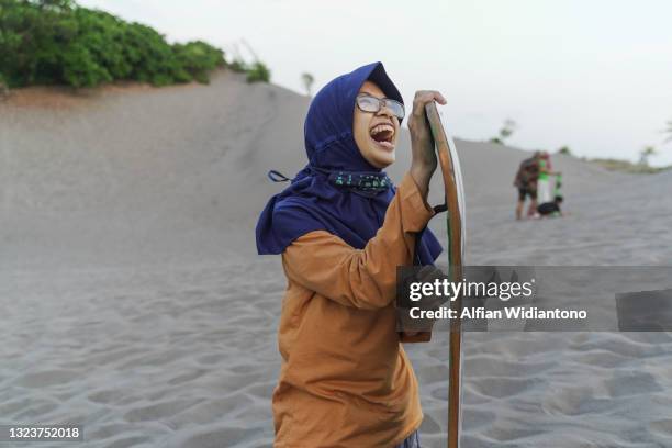 young girl doing sandboarding - sand boarding stock pictures, royalty-free photos & images