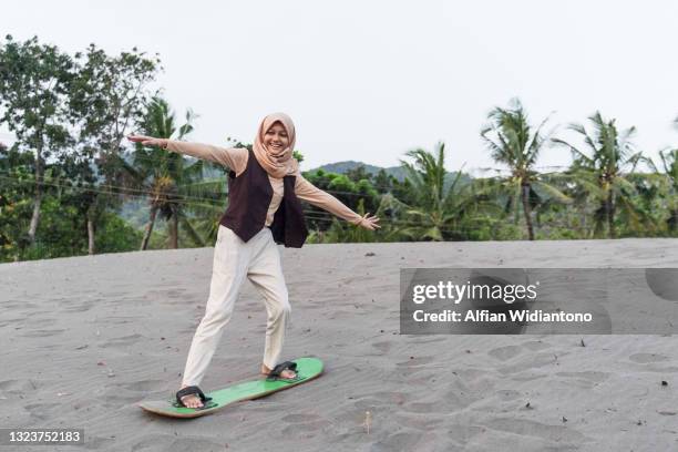 young girl doing sandboarding - hijab girl stock-fotos und bilder