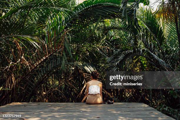 熱帯公共公園で熱帯の雰囲気を楽しむ美しい幸せな女性 - rainforest garden ストックフォトと画像