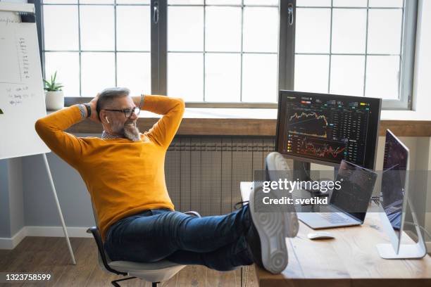 mature businessman trading with cryptocurrency - happy businessman working at his office with laptop stock pictures, royalty-free photos & images