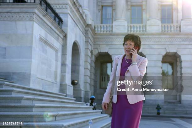 Senator Susan Collins talks on the phone as she walks to board a bus at the U.S. Capitol before being driven to U.S. Vice President Kamala Harris's...