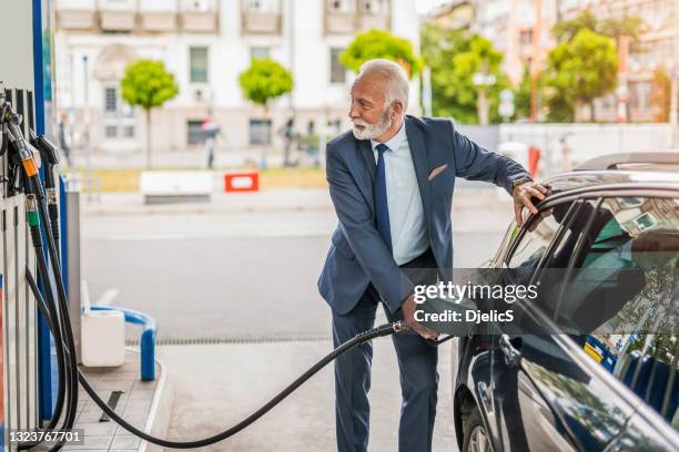 senior man refueling his car the gas station. - refueling 個照片及圖片檔