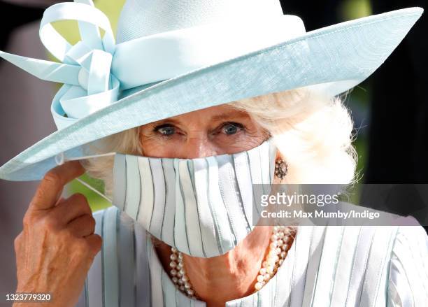 Camilla, Duchess of Cornwall adjusts her face mask as she attends day 1 of Royal Ascot at Ascot Racecourse on June 15, 2021 in Ascot, England.