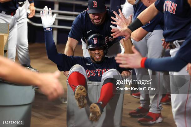 Xander Bogaerts of the Boston Red Sox celebrates as he is pushed in a clothing cart after a solo homer in the fifth inning against the Atlanta Braves...