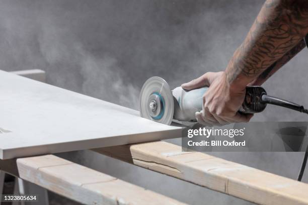 man with tattoo cutting kitchen countertop with saw - quartz kitchen stock pictures, royalty-free photos & images