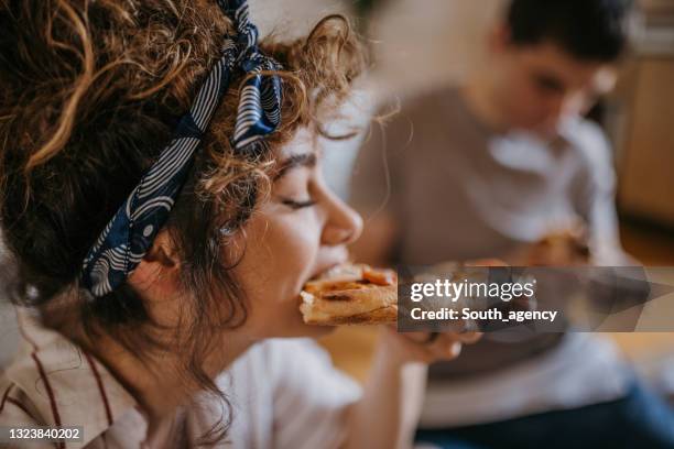 pareja jugando a comer pizza en casa - pizza fotografías e imágenes de stock