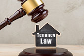Real estate concept -auction gavel and little house with inscription Tenancy law