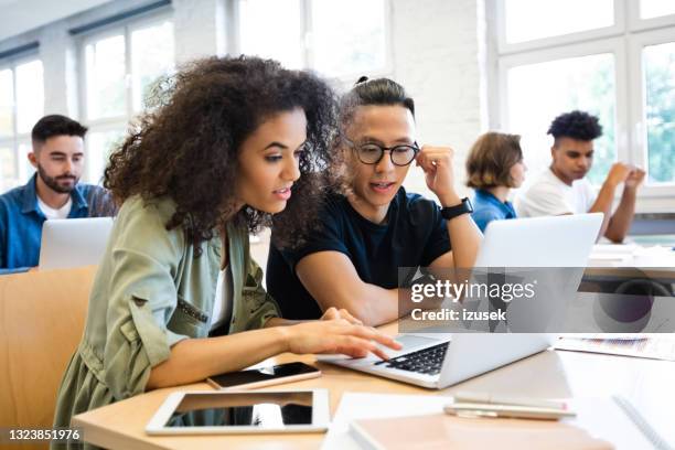 classmates are learning through laptop - studeren stockfoto's en -beelden