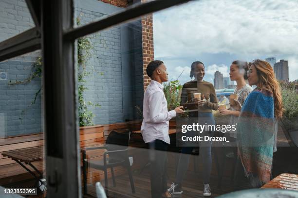 grupo de diversos empresários bebendo café e conversando na varanda no local de trabalho - pausa para o café - fotografias e filmes do acervo