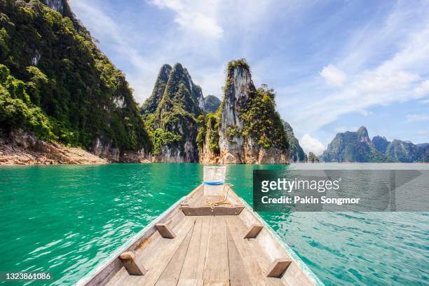 traditional longtail boat with beautiful scenery view in ratchaprapha dam at khao sok national park - longtailboot stockfoto's en -beelden