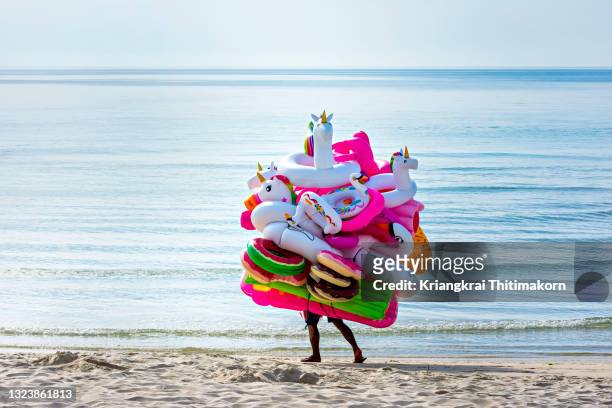 an illusion of a man carrying balloons. - multi colored hat stock pictures, royalty-free photos & images