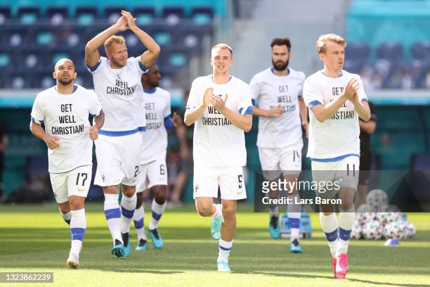 Nikolai Alho of Finland enters the pitch for the warm up wearing 'Get well Christian Eriksen' shirts prior to the UEFA Euro 2020 Championship Group B...