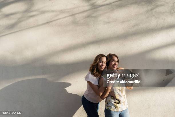 linda madre e hija latinas de pie juntas afuera - 50 sombras fotografías e imágenes de stock