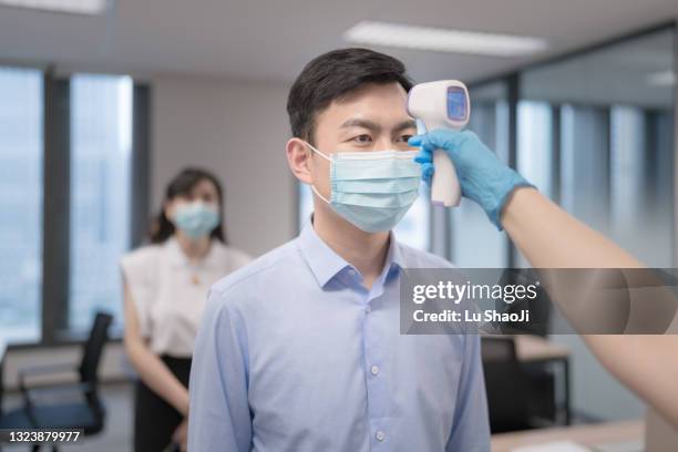 employees going through temperature checks in office - china coronavirus 個照片及圖片檔