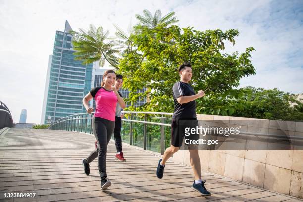 eine gruppe junger freunde in sportkleidung läuft an einem strahlend sonnigen morgen - läufer dramatisch stock-fotos und bilder
