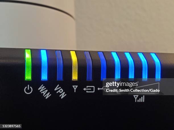 Close-up of illuminated lights on a cable modem, including WAN, VPN, and sign strength lights, Lafayette, California, May 17, 2021.