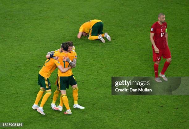 Players of Wales celebrate after victory as Burak Yilmaz of Turkey looks dejected following the UEFA Euro 2020 Championship Group A match between...