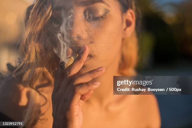 close-up of woman smoking cigarette,port elizabeth,south africa - weed stockfoto's en -beelden