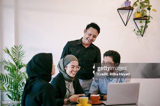 groupe de jeunes ayant une discussion dans un espace de coworking moderne - indonesian ethnicity photos et images de collection