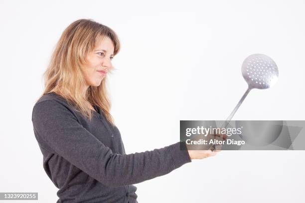 threatening woman with a frying pan in her hand. - lady cooking confused imagens e fotografias de stock