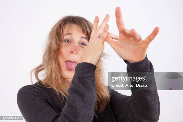 woman making mocking gestures with her hands and tongue. - teasing stock pictures, royalty-free photos & images