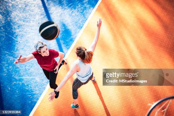 directly above two women playing basketball - women's basketball stockfoto's en -beelden