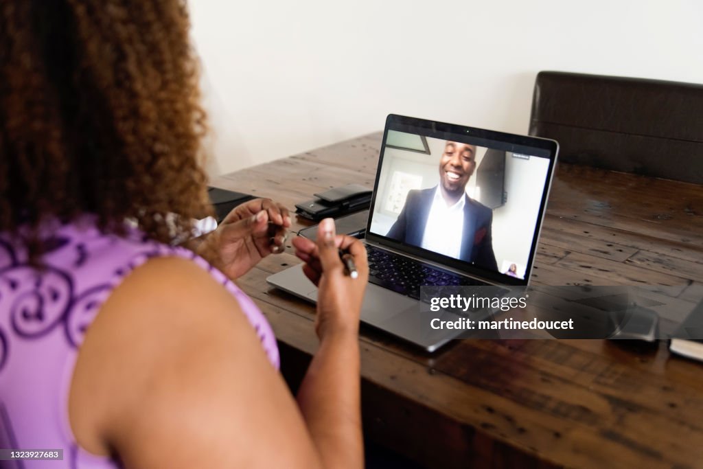 Mujer afroamericana madura que trabaja desde casa en teleconferencia.