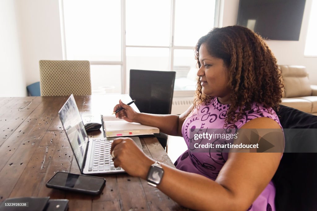 Mature African-American woman working from home in teleconference.