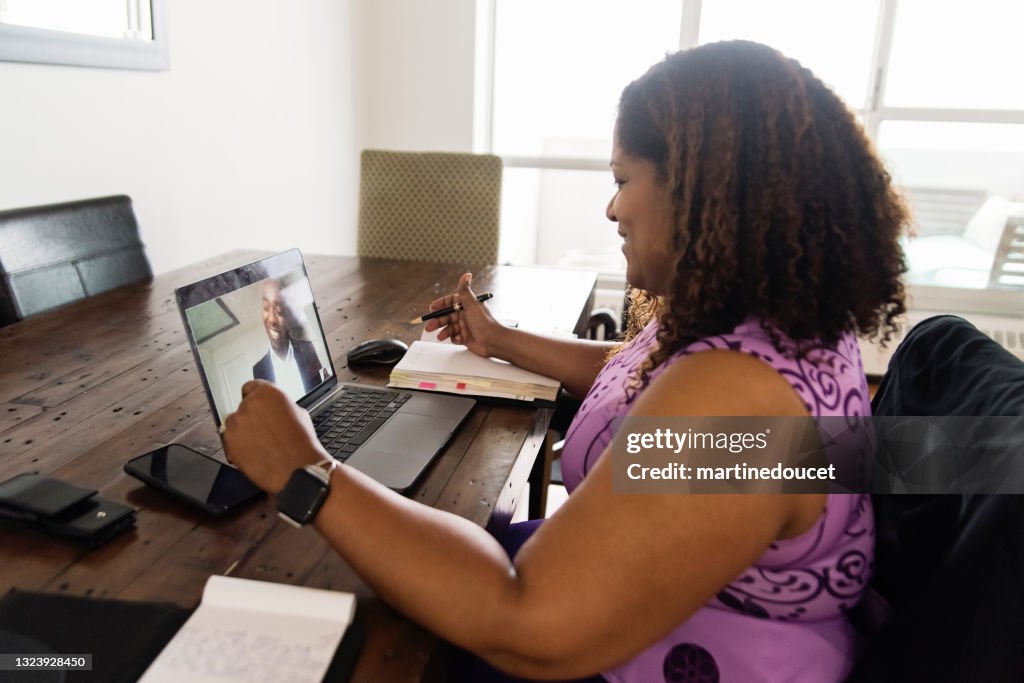 Mature African-American woman working from home in teleconference.