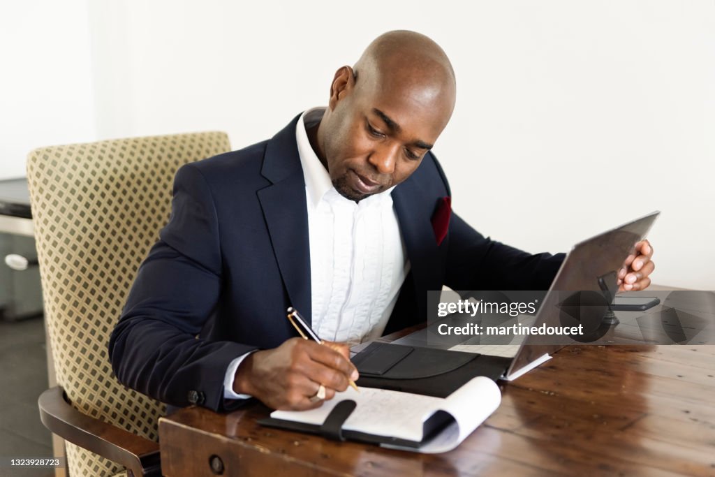 Homem afro-americano maduro trabalhando em casa.