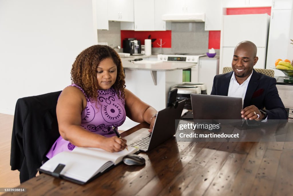 Mature African-American couple working from home.