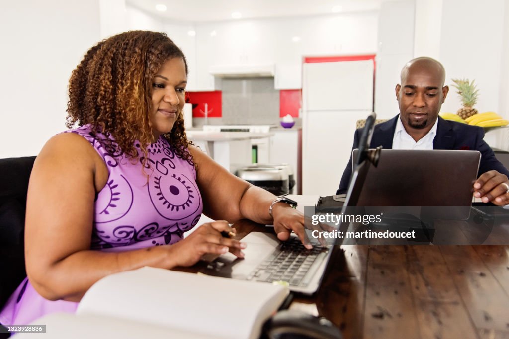 Casal afro-americano maduro trabalhando em casa.