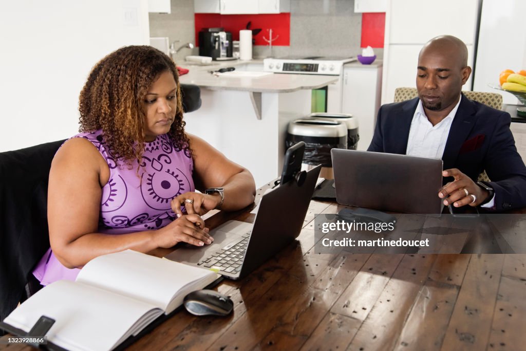 Mature African-American couple working from home.