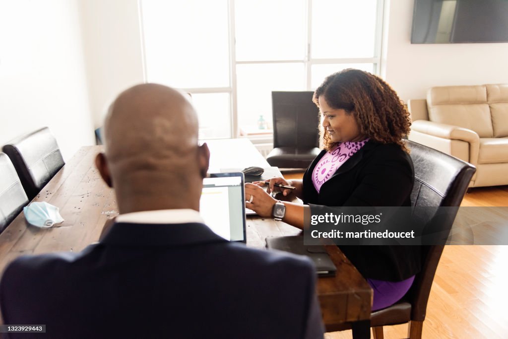 Mature African-American couple working from home.