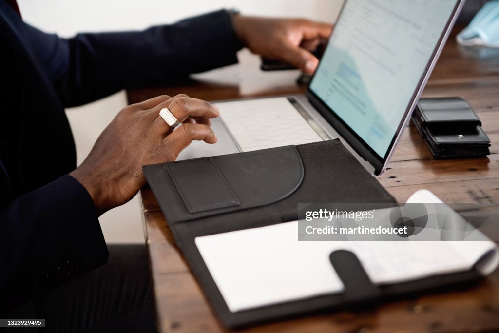 Close-up on African-American man's hand working from home.