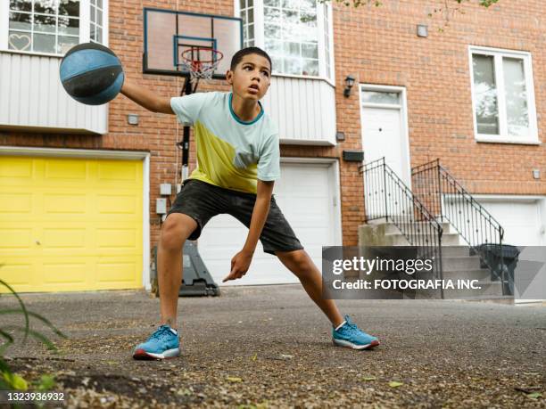 mixed race boy playing basketball in the alley - basketball hoop bildbanksfoton och bilder