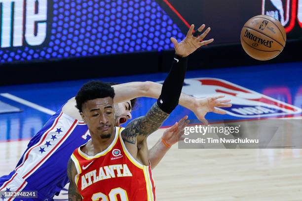 John Collins of the Atlanta Hawks fouls Furkan Korkmaz of the Philadelphia 76ers during the first quarter during Game Five of the Eastern Conference...