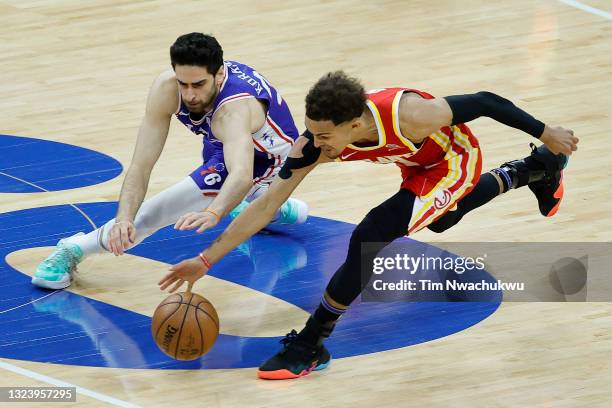 Furkan Korkmaz of the Philadelphia 76ers and Trae Young of the Atlanta Hawks reach for a loose ball during the third quarter during Game Five of the...