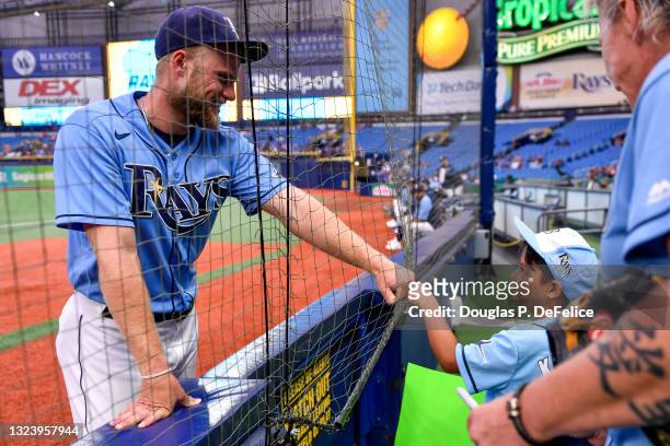 Austin Meadows of the Tampa Bay Rays fist pumps a fan prior to the game against the Baltimore Orioles at Tropicana Field on June 12, 2021 in St...
