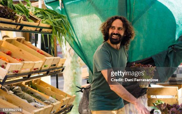 organic market vendor enjoying his job - food market stockfoto's en -beelden